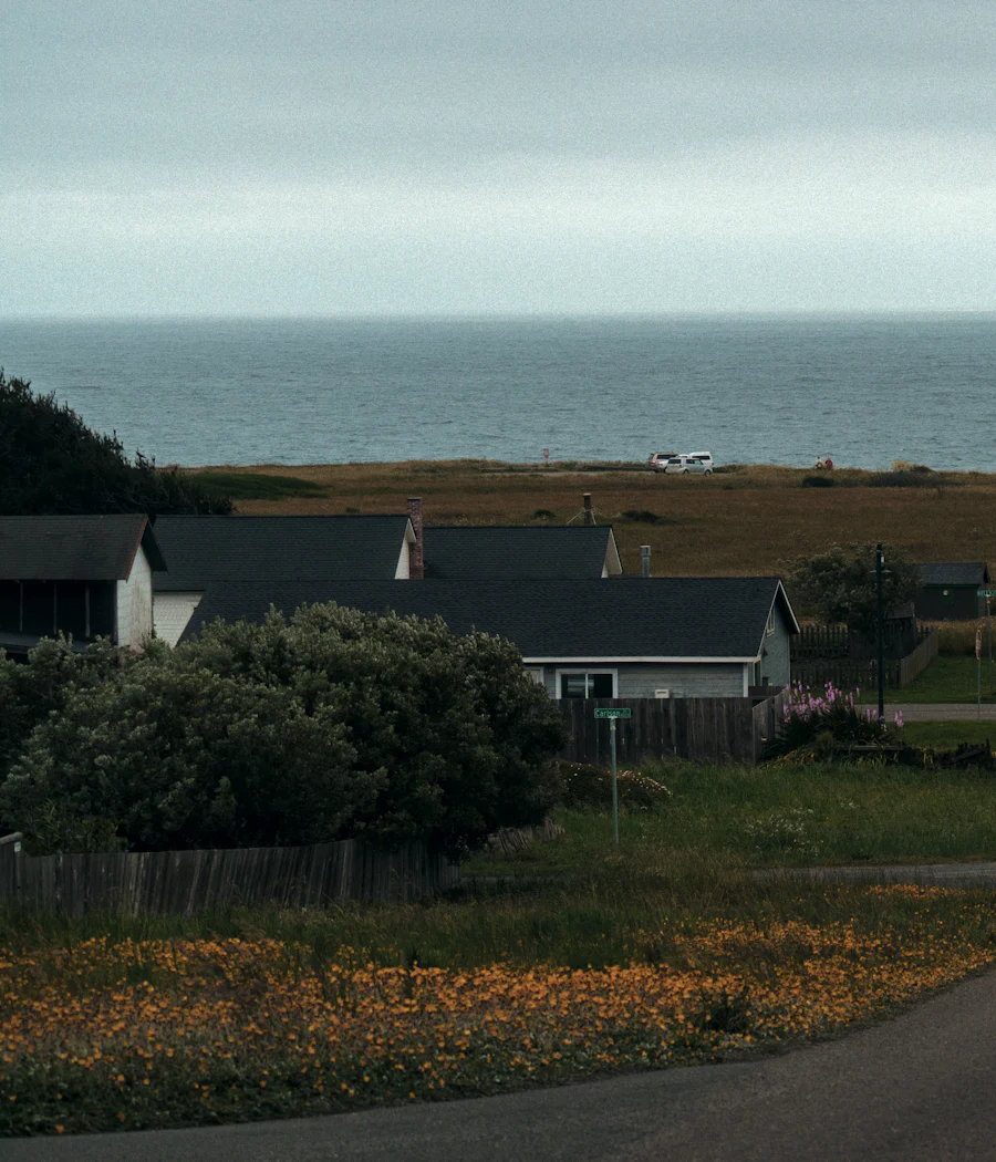 A straight road through fields leading down to the sea